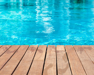 Fototapeta na wymiar Traces de pas humides sur plage de piscine en bois