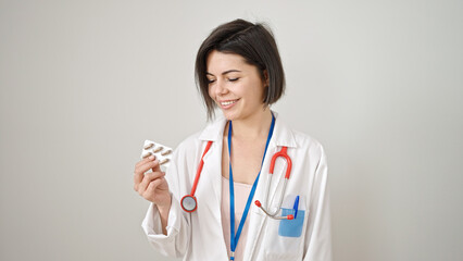 Young caucasian woman doctor holding pills over isolated white background