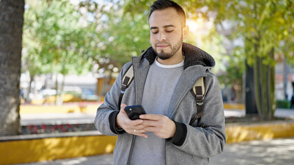 Hispanic man using smartphone at the park