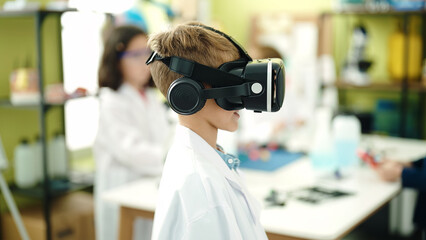 Adorable caucasian boy student using virtual reality glasses at laboratory classroom