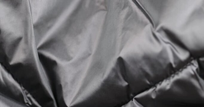 crumpled gray material in close-up, part of the fabric from gray-tinged clothing