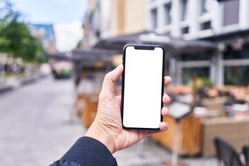 Man holding smartphone showing white blank screen at coffee shop terrace