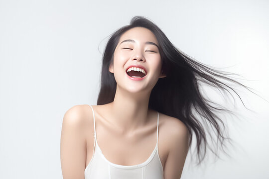 Charming Asian teenager with long hair blowing in the breeze exudes positivity with a bright smile on a white background. generative ai.