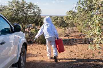 A beekeeper carries water in a red carafe to the hives. Beekeeping concept 