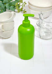 Green bottle of detergent. Set of clean cookware. Washing dishes at home.