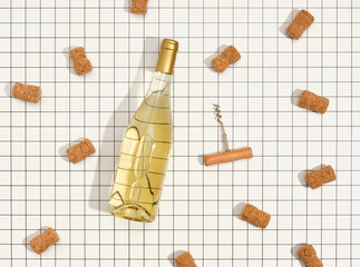 A bottle of white wine, a corkscrew and lots of bottle corks. Top view. Concept of festive birthday party.