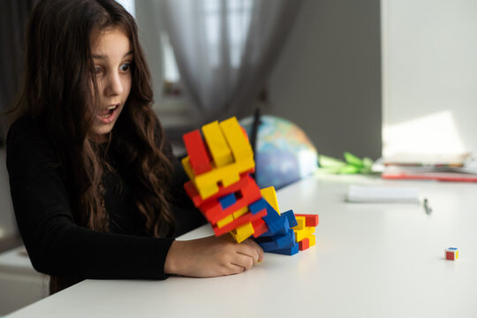 Children building wood blocks at playground. Girl kid playing stacking wood blocks (Jenga games) for meditation practice. Hand movement control Building Computational Skills Children's play concept.