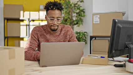 African american man ecommerce business worker using laptop sitting on table at office
