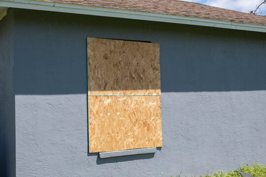 Plywood Storm Shutters For Hurricane Protection Of House Windows. Protective Measures Before Natural Disaster In Florida