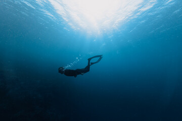Free diver swimming into the deepness