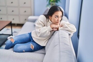 Obraz premium Young hispanic woman stressed sitting on sofa at home