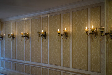 Vintage golden wallpaper with pattern. Sconce fixture lighting