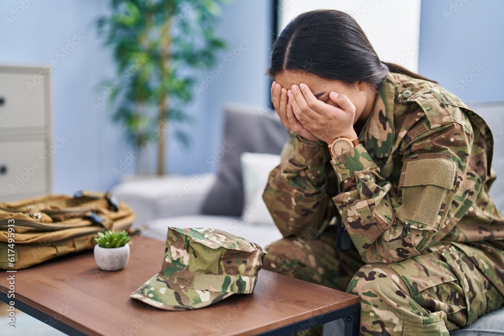 Sticker young hispanic woman army soldier depressed sitting on sofa at home