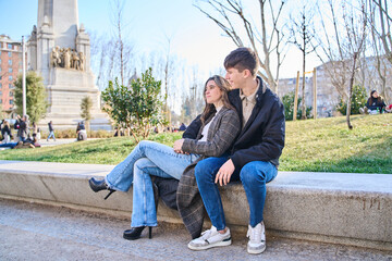 young couple sitting on a bench in the city. couple hugging and resting.