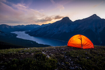 Glowing tent set up on a ridge for camping in the Rocky mountains