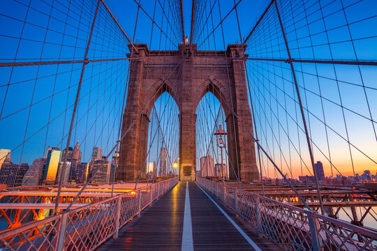 Cityscape image of Brooklyn Bridge with Manhattan skyline in the background.