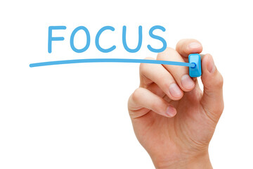 Hand writing Focus with blue marker on transparent wipe board.