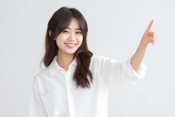 Pointing finger of an Asian girl highlights vacant space on a white background, making it a prime choice for a promotional advertising banner. Generative AI.