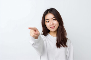 Pointing finger of an Asian girl highlights vacant space on a white background, making it a prime choice for a promotional advertising banner. Generative AI.