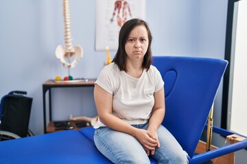 Hispanic girl with down syndrome at physiotherapy clinic thinking attitude and sober expression...