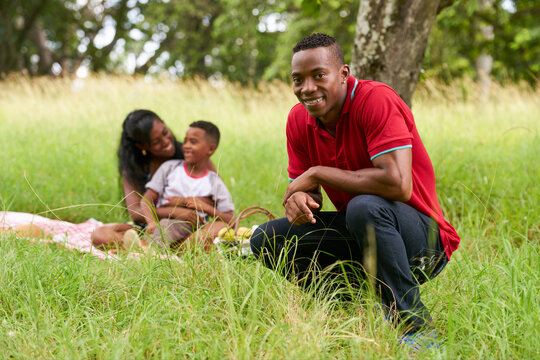 Happy black people in city park. African american family with young father, mother and son during picnic. Leisure for husband, wife and boy.