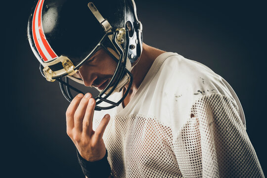 Confident football player with protective helmet posing
