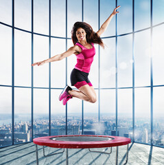 Fitness teacher jumps nimbly on the trampoline at the modern gym