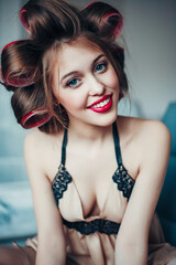 Beauty portrait of young woman wearing curlers and vintage lingerie. Professional make-up and hairstyle. Perfect skin. Fashion photo. Retro style.