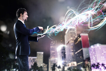 Businessman working with laptop with light effects on the city background. Work with new connections concept