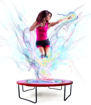 Fitness teacher jumps nimbly on the trampoline with colour light effect
