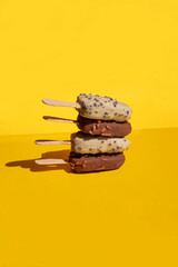 white and milk chocolate, ice cream stick balance on a yellow background