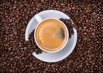 cup of coffee with beans in the background