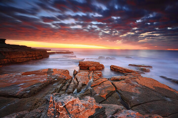 Simply stunning sunrise long exposure at dawn.   Swift movement in the clouds as they swept in fast.  The warm sunrise light highlighting the clouds and the colours in the rocks and enhancing the warm