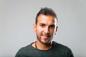 studio shot (portrait) of a latin-american handsome young man that appears not too model-like but natural