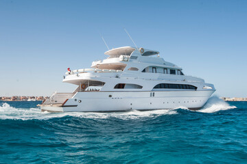 A large private motor yacht under way sailing out on tropical sea