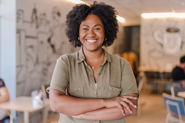 poportrait of a coffee shop barista in Brazil with her arms crossed smiling at the camera