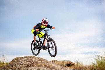 Naklejka premium Professional Cyclist Riding the Bike Down Rocky Hill. Extreme Sport Concept. Free Space for Text.