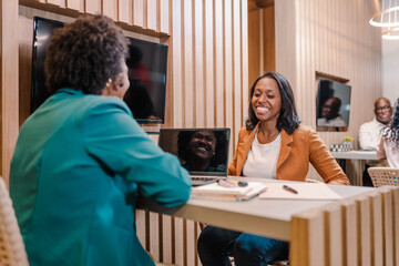 Brazilian woman smiling sitting at her account manager's desk at a bank in Brazil to apply for bank credit