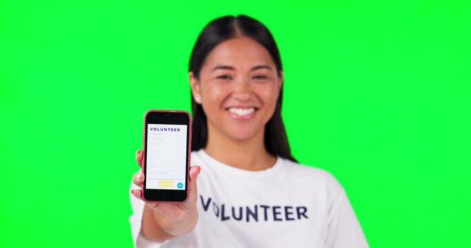 Phone, volunteer and a woman on a green screen background for charity website fund information. Asian person hand with smartphone and tshirt for nonprofit contact, NGO app or donation and ui mockup