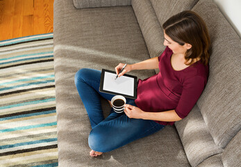 Beautiful woman at home in the sofa and working with a tablet