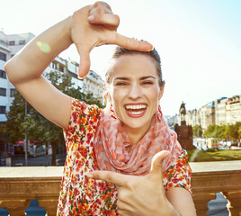 Obraz premium The spirit of old Europe in Prague. Portrait of smiling modern traveller woman on Vaclavske namesti in Prague, Czech Republic with hands framing