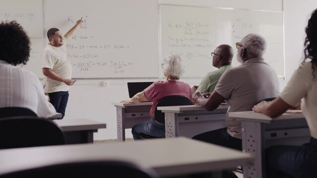professor Brasileiro dando aula de matematica para uma turma de adultos e isodos em uma universidade no Brasil