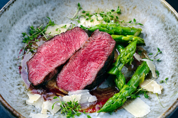 Gourmet barbecue dry aged angus beef steak with green asparagus and parmesan cheese in truffle...