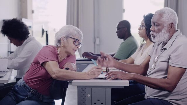 senhora idosa aluna de uma turma para adultos no Brasil brincando com seu colega de classe durante a aula
