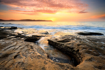 Fototapeta na wymiar Spectacular sunrise beautiful skies and light from the rocky coastline near Pearl Beach, Australia