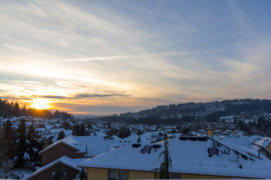 Happy Valley Oregon suburban neighborhood homes covered in snow during winter sunset