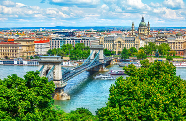 Fototapeta na wymiar Chain bridge on Danube river in Budapest city, Hungary. Urban landscape panorama with old buildings and domes of opera buildings