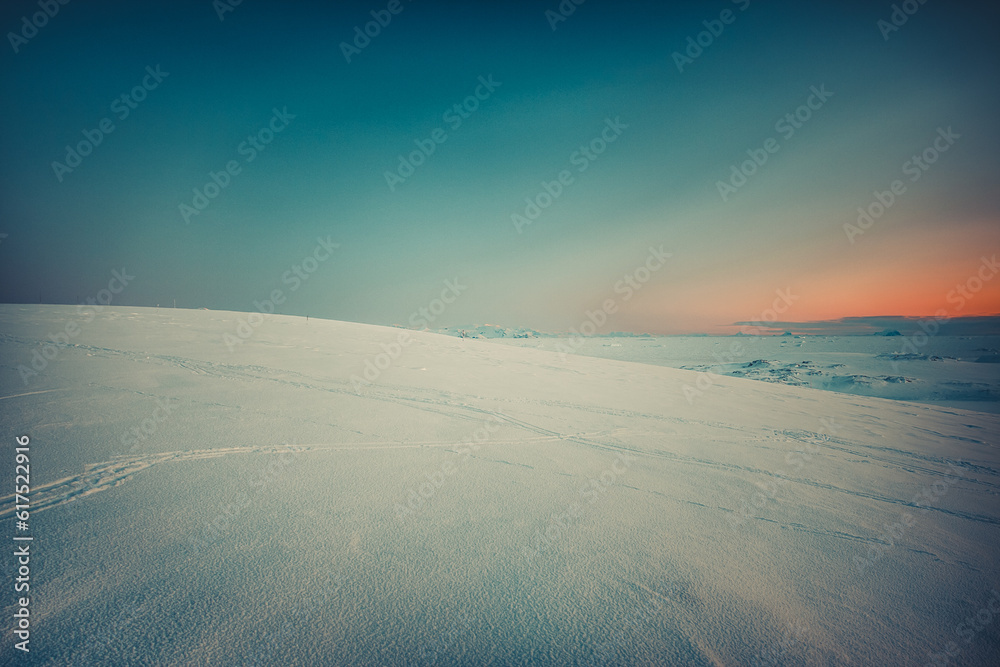 Sticker curly trace of skies on the snow in antarctica. mountains in the background. vintage toning effect. 