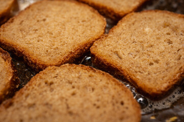 An appetizer for beer and a great addition to first courses. Natural toasts from rye bread. White crackers. Butter croutons, short black Borodino croutons. The process of cooking in a pan