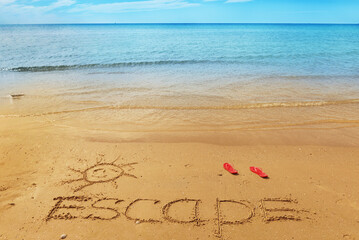 Escape message on the beach sand - vacation and travel concept